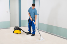 stock-photo-82843993-male-cleaner-vacuuming-floor